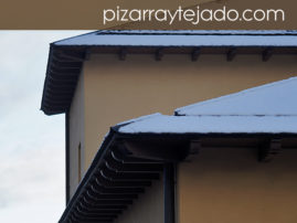 Nieve sobre cubiertas de pizarra sin canalones.