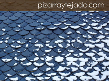 Tejados de pizarra natural con nieve.