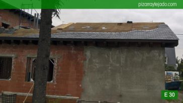 Inicio de colocación de pizarra negra 50x25 de León en tejado de pizarra en Madrid.