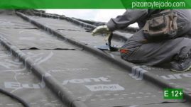 Colocación de membrana impermeable y transpirable sobre rastrel de madera de castaño en cubierta de pizarra natural.