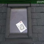 Montaje de ventana en el tejado de una casa con tejado de pizarra.