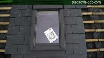 Montaje de ventana en el tejado de una casa con tejado de pizarra.