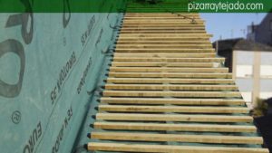 Colocación de rastrel de madera en tejado de pizarra.
