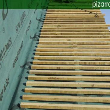 Colocación de rastrel de madera en tejado de pizarra.